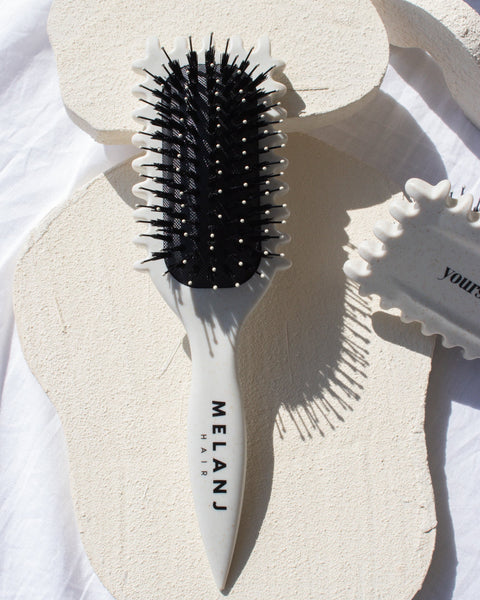 hairbrush with bristles and vented sides for curl clumping and defining