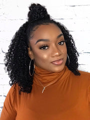 A woman showcasing her natural curls in a protective style, styled with corkscrew curl clip-ins for coily and curly hair texture.