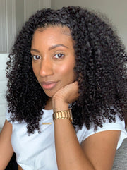 A woman showcasing her natural curls styled with corkscrew curl clip-in hair extensions. The hair has a voluminous and curly appearance.