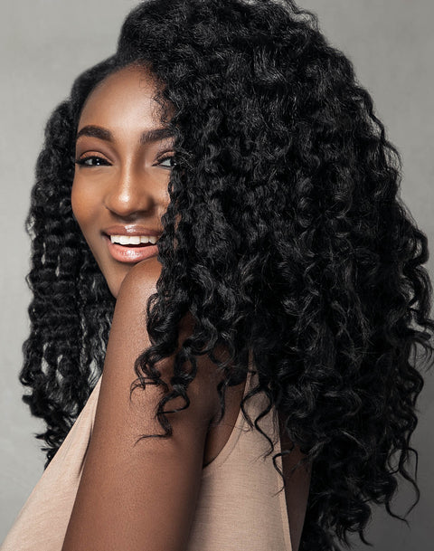 Black woman in kinky straight clip-in hair extensions for natural hair; worn in braided blow out style, silk press, relaxed blow out, roller set on natural hair